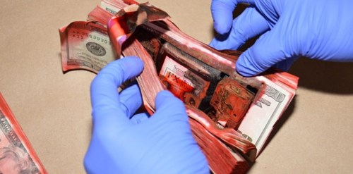 An activated dye pack stains bills with red dye
